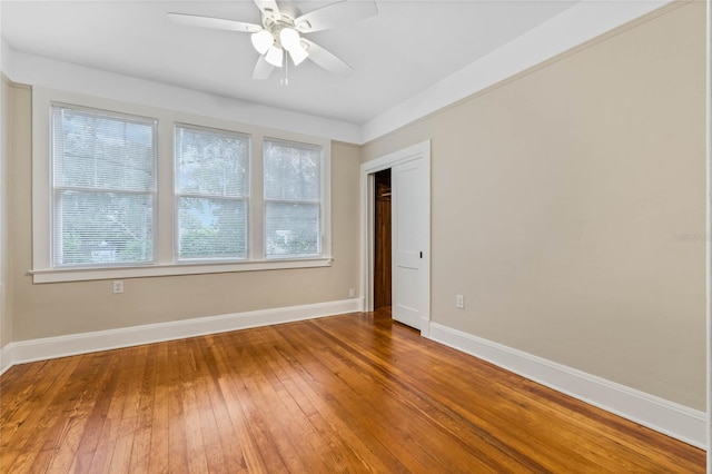 spare room with ceiling fan, baseboards, and hardwood / wood-style floors