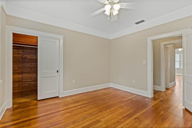 unfurnished room featuring ceiling fan, light wood-style flooring, visible vents, and baseboards