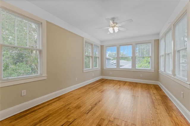 empty room with a healthy amount of sunlight, light wood-style flooring, and baseboards