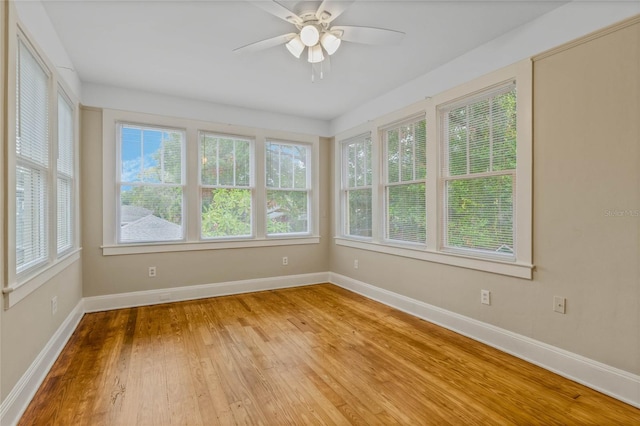 unfurnished sunroom with a ceiling fan and plenty of natural light