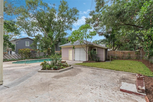 exterior space featuring an outbuilding, a fenced backyard, a lawn, a fenced in pool, and a patio area