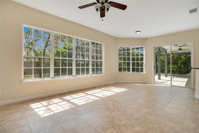 spare room with plenty of natural light, tile patterned floors, visible vents, and baseboards