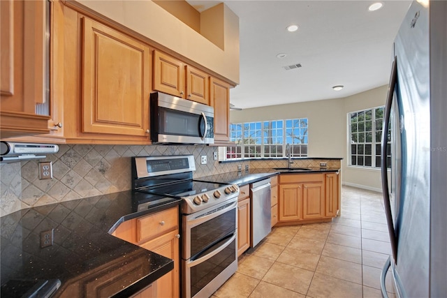 kitchen with light tile patterned floors, visible vents, decorative backsplash, stainless steel appliances, and a sink