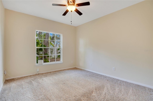 carpeted spare room with ceiling fan and baseboards