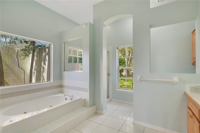 bathroom featuring a stall shower, baseboards, a tub with jets, tile patterned floors, and vanity