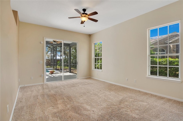 carpeted spare room featuring ceiling fan and baseboards