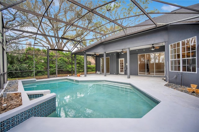 pool with glass enclosure, a patio, and ceiling fan