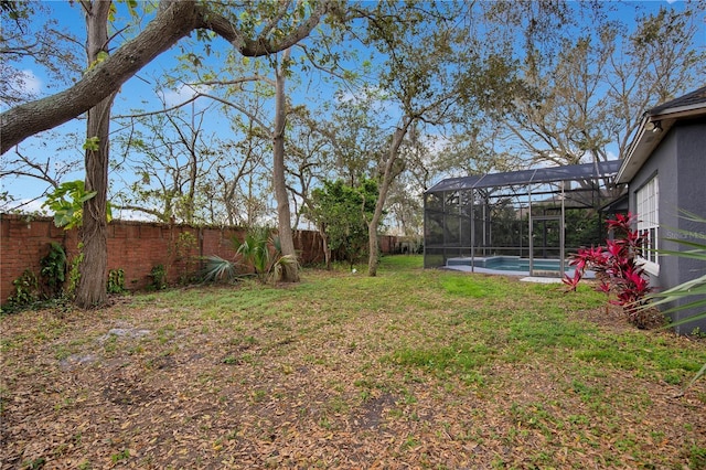 view of yard with a fenced in pool, glass enclosure, and a fenced backyard