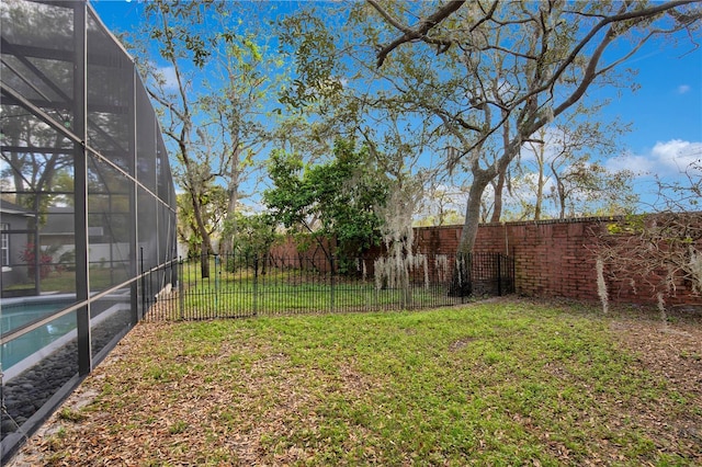 view of yard with a lanai, a fenced backyard, and a fenced in pool