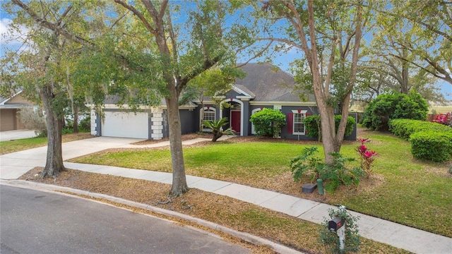 view of front facade with a front yard, driveway, and an attached garage