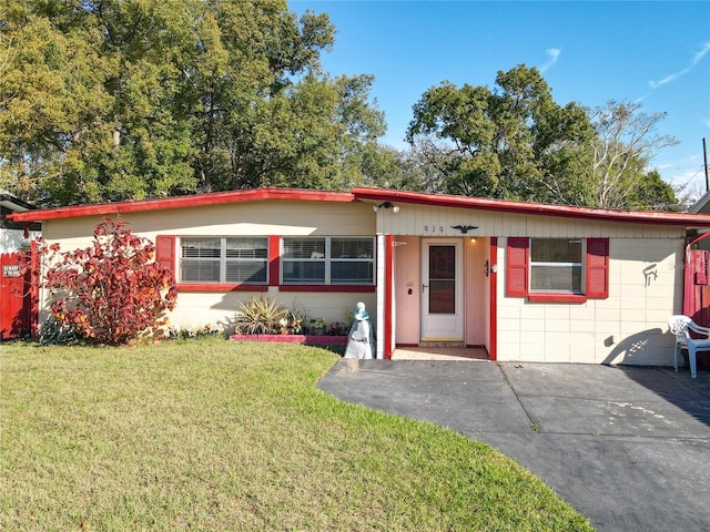 view of front of house with concrete block siding and a front yard