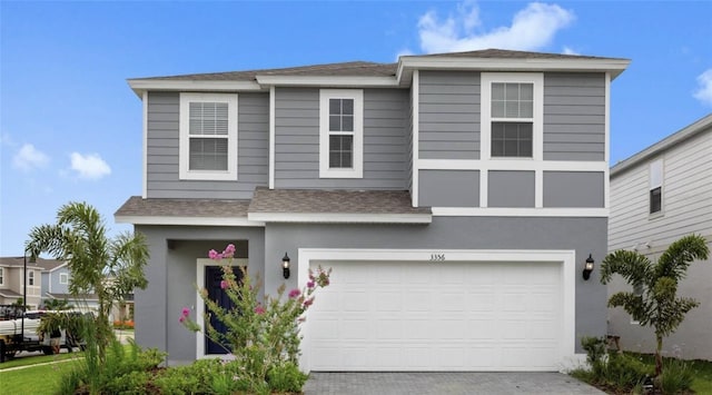 view of front of home featuring a garage, roof with shingles, decorative driveway, and stucco siding