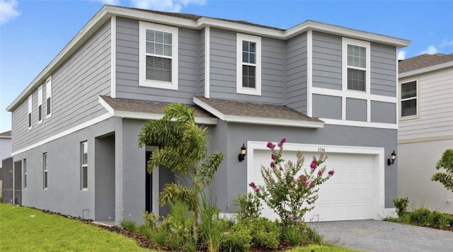 view of side of home with a shingled roof, driveway, an attached garage, and stucco siding