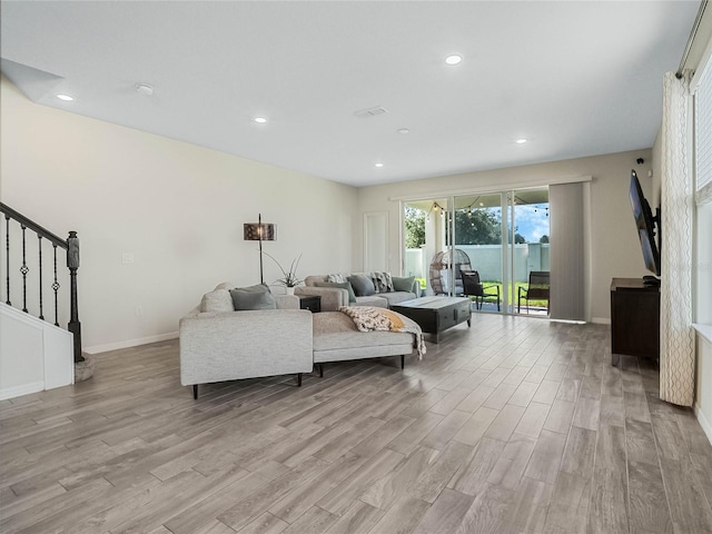 living area with light wood-style flooring, baseboards, stairs, and recessed lighting