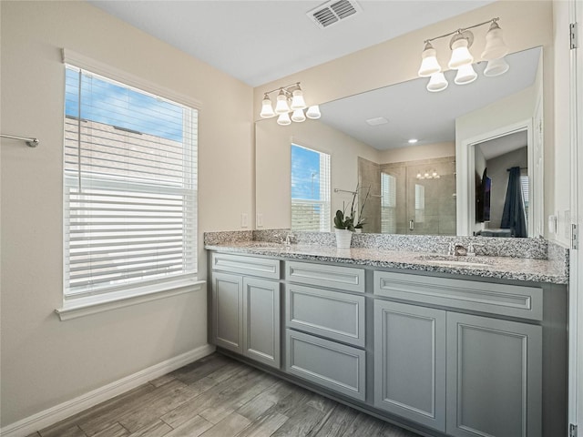 bathroom featuring a stall shower, a chandelier, wood finished floors, baseboards, and visible vents