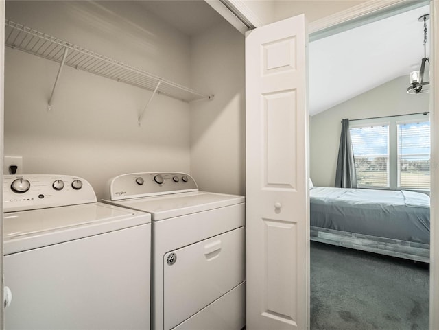clothes washing area with carpet flooring, washing machine and clothes dryer, and laundry area