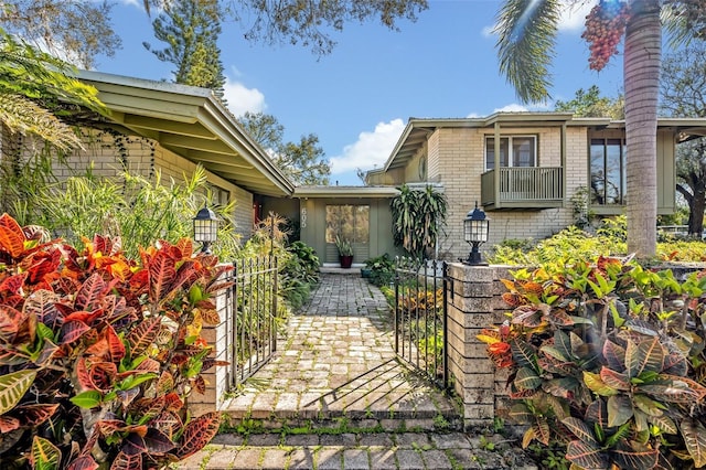 view of front of property with a gate and brick siding