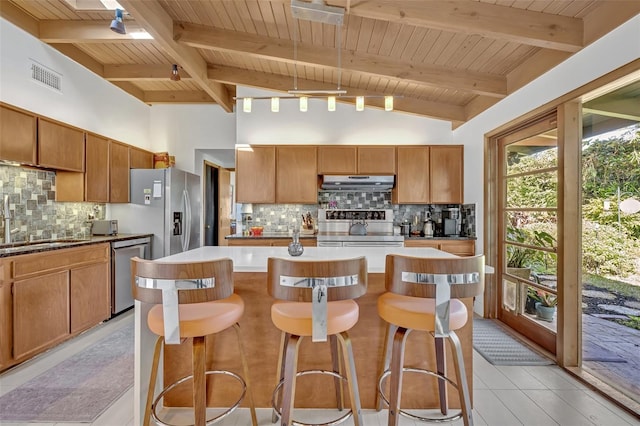 kitchen with visible vents, wooden ceiling, appliances with stainless steel finishes, a center island, and under cabinet range hood