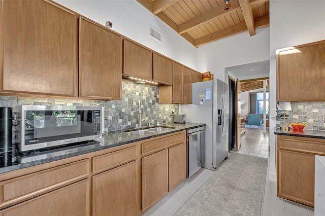 kitchen featuring stainless steel appliances, dark stone countertops, and light tile patterned flooring