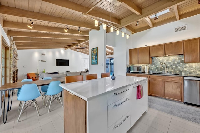 kitchen with a sink, wood ceiling, appliances with stainless steel finishes, backsplash, and brown cabinetry