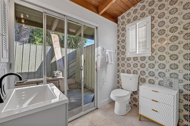 bathroom with toilet, baseboards, a sink, and tile patterned floors