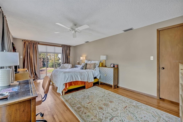 bedroom featuring a textured ceiling, ceiling fan, visible vents, access to exterior, and light wood-type flooring