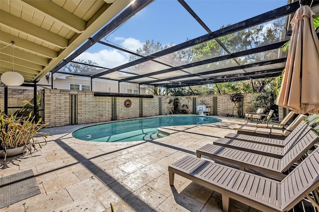 view of swimming pool featuring a lanai, fence, a fenced in pool, and a patio