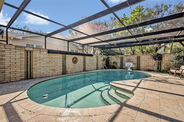 view of swimming pool with a patio area, a lanai, a fenced in pool, and fence