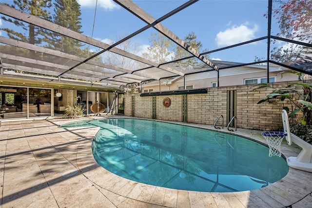 outdoor pool with glass enclosure and a patio