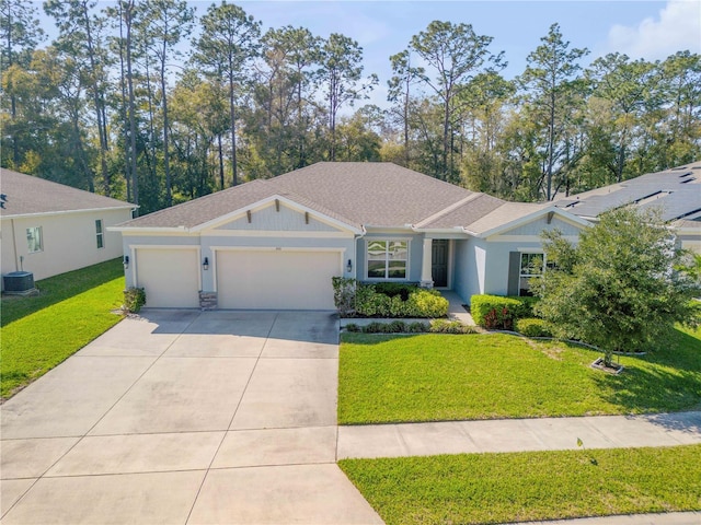 ranch-style house with central air condition unit, roof with shingles, concrete driveway, a front yard, and a garage