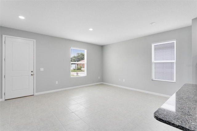 unfurnished living room with baseboards and recessed lighting