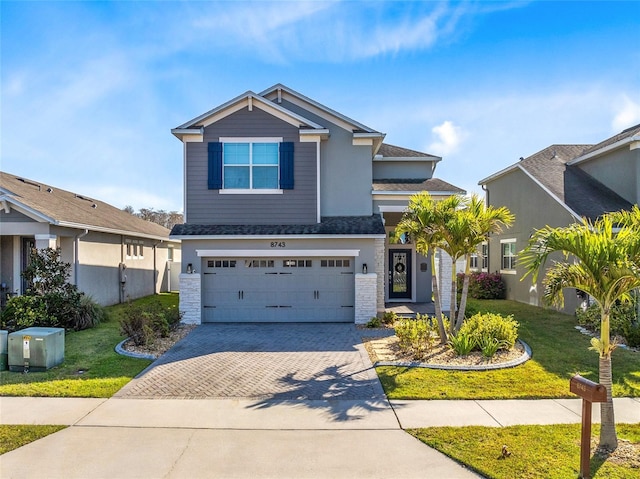 view of front facade featuring a garage, decorative driveway, and a front yard