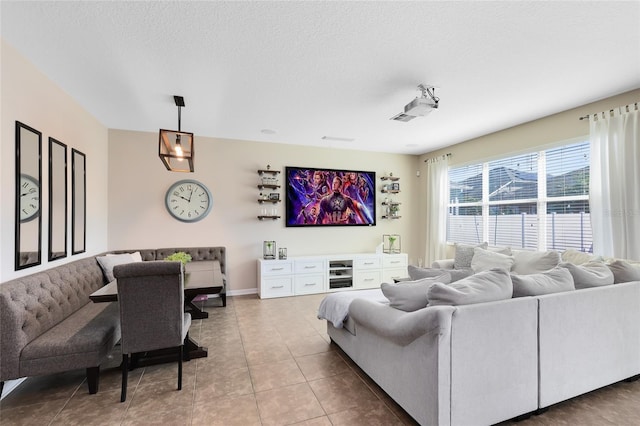 tiled living room featuring a textured ceiling and baseboards