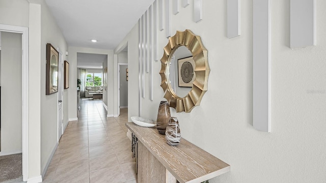 hall with light tile patterned floors and baseboards