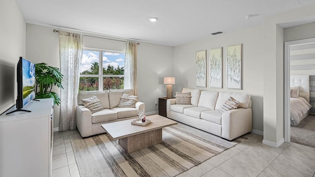 living area with light tile patterned floors, visible vents, and baseboards