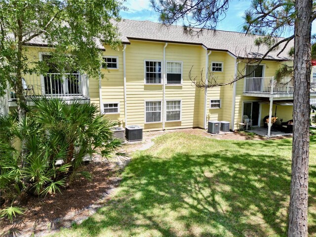 2040 Royal Bay Blvd Unit 30, Kissimmee, FL 34746 - back of house featuring central AC, a lawn, and a patio