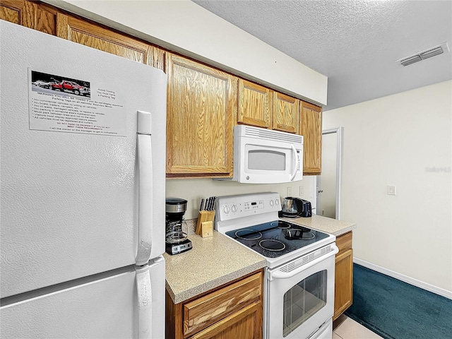 2040 Royal Bay Blvd Unit 30, Kissimmee, FL 34746 - kitchen featuring a textured ceiling, white appliances, visible vents, baseboards, and light countertops