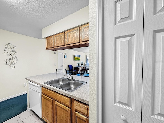 2040 Royal Bay Blvd Unit 30, Kissimmee, FL 34746 - kitchen featuring light countertops, brown cabinetry, white dishwasher, and a sink