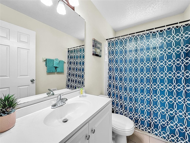 2040 Royal Bay Blvd Unit 30, Kissimmee, FL 34746 - full bathroom featuring a shower with shower curtain, toilet, a textured ceiling, vanity, and tile patterned flooring