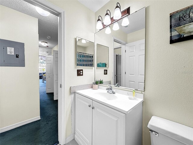 2040 Royal Bay Blvd Unit 30, Kissimmee, FL 34746 - bathroom with a textured ceiling, a textured wall, toilet, vanity, and electric panel