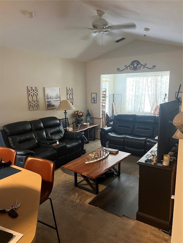 living room with vaulted ceiling, carpet floors, visible vents, and a ceiling fan