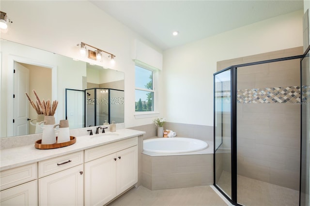 bathroom featuring a stall shower, a garden tub, vanity, and tile patterned floors