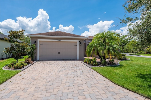 view of front facade with an attached garage, decorative driveway, a front yard, and stucco siding