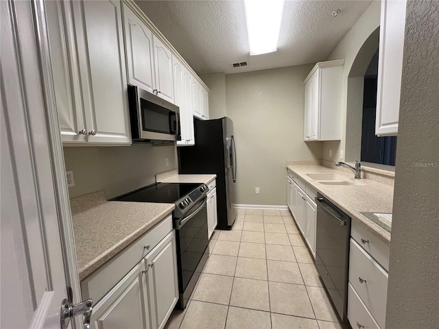 kitchen featuring stainless steel appliances, light countertops, visible vents, a sink, and a textured ceiling