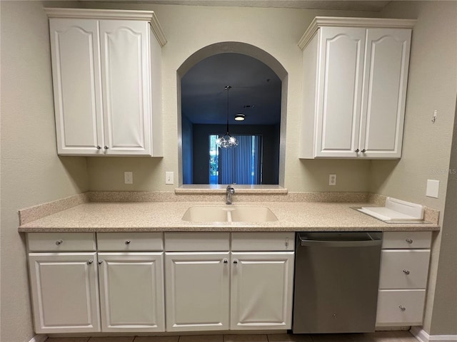 kitchen with light countertops, white cabinets, dishwasher, and a sink