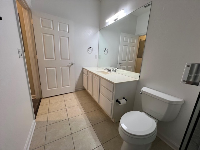 bathroom with toilet, vanity, baseboards, and tile patterned floors