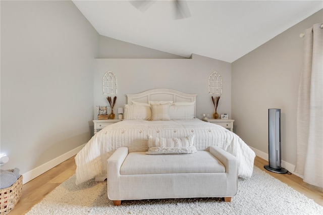 bedroom with lofted ceiling, ceiling fan, wood finished floors, and baseboards