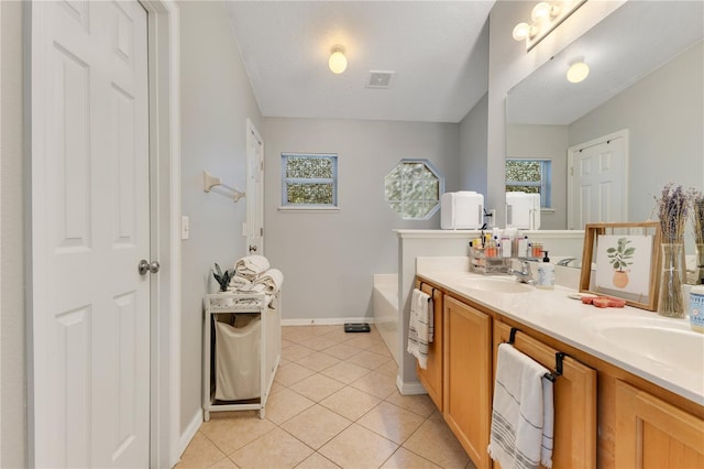 bathroom featuring double vanity, visible vents, a garden tub, tile patterned flooring, and a sink