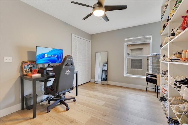 office area featuring a ceiling fan, baseboards, and wood finished floors