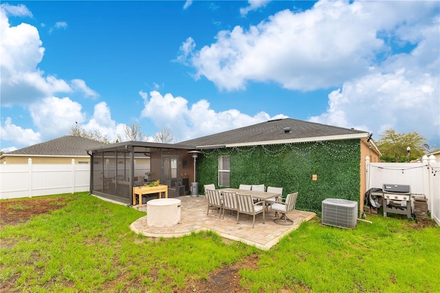 back of property with a yard, central air condition unit, a sunroom, a patio area, and a fenced backyard